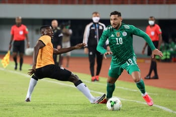 Amine Messoussa portant le maillot vert avec le numéro 10 en duel avec un adversaire.
