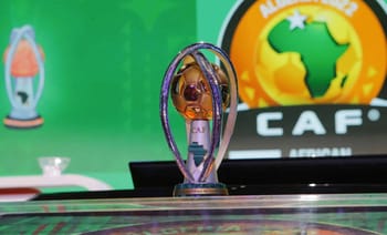 Trophée du CHAN 2025 avec logo de la CAF en arrière-plan.