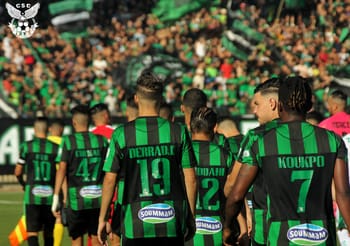 Équipe de football en vert et noir lors d'un match.