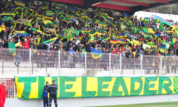 Supporters de JSK avec drapeaux et banderoles au stade.