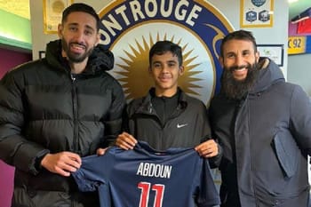 Jeune joueur avec deux hommes, tenant maillot PSG, dans un centre sportif.