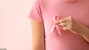 Femme en rose tenant un ruban rose, symbole de la lutte contre le cancer du sein.