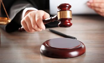 Juge frappant le marteau lors d'une audience judiciaire.