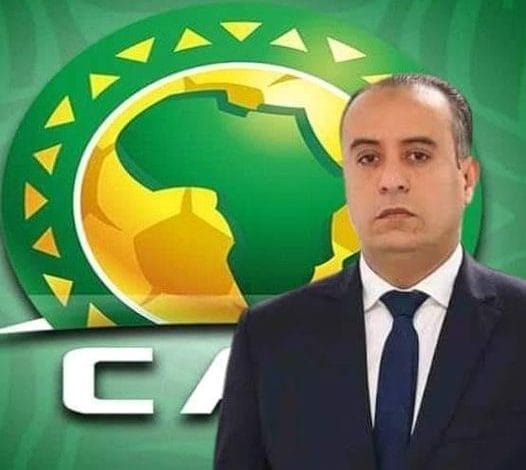 Walid Sadi en costume devant le logo de la CAF.