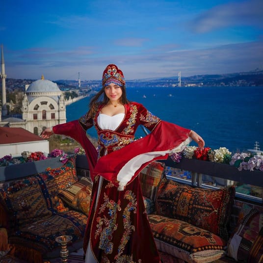 Femme en costume traditionnel turc avec vue sur Bosphore à Istanbul.