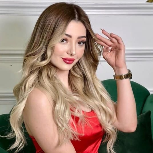Jeune femme avec cheveux longs blonds et maquillage sophistiqué.