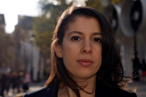 Nadia Henni-Moulaï : «Les Algériens n’ont jamais cessé de se battre » Portrait de Nadia Henni-Moulaï dans une rue urbaine ensoleillée.