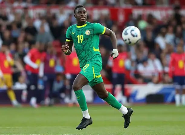 Footballeur en mouvement portant le maillot vert de l'équipe nationale.