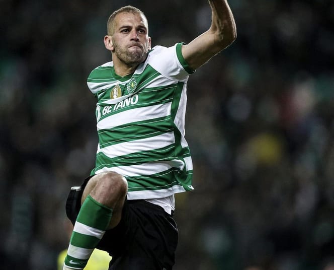 Joueur de football en maillot vert et blanc en pleine action sur le terrain.
