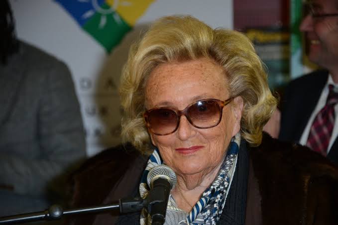 Bernadette Chirac portant des lunettes et parlant à une conférence.