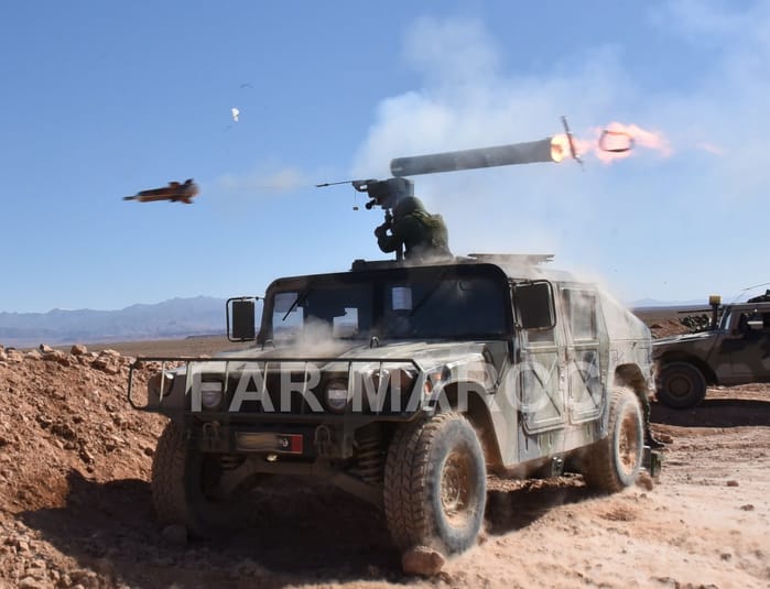 Lancement d'un missile antichar HJ-9A depuis un véhicule militaire dans le désert.