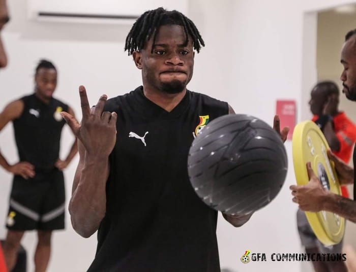 Footballeur ghanéen en entraînement avec ballon et équipe.