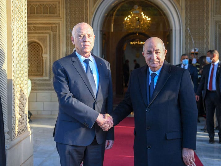 Deux dirigeants maghrébins se serrent la main lors d'une cérémonie officielle.