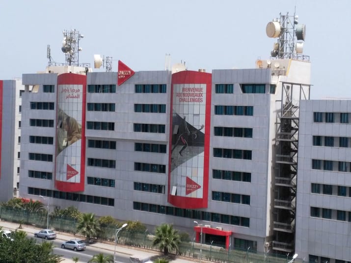 Télécom : Djezzy et Ouedkniss signent un accord pour le bonheur des clients Bâtiment de Djezzy avec panneaux publicitaires et antennes de télécommunications.