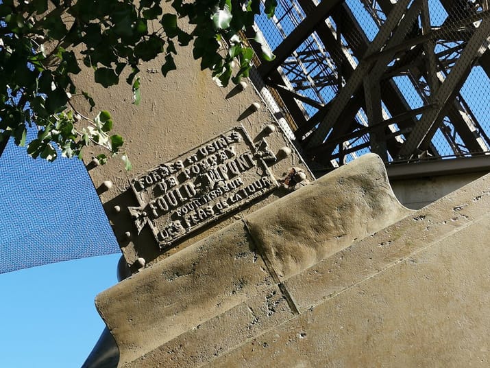 France : Découvrez l'origine du fer de la Tour Eiffel Plaque en fer avec inscription sur la Tour Eiffel, symbole de l'histoire du fer.