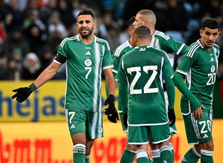 Groupe de joueurs maghrébins en tenue verte lors d'un match.