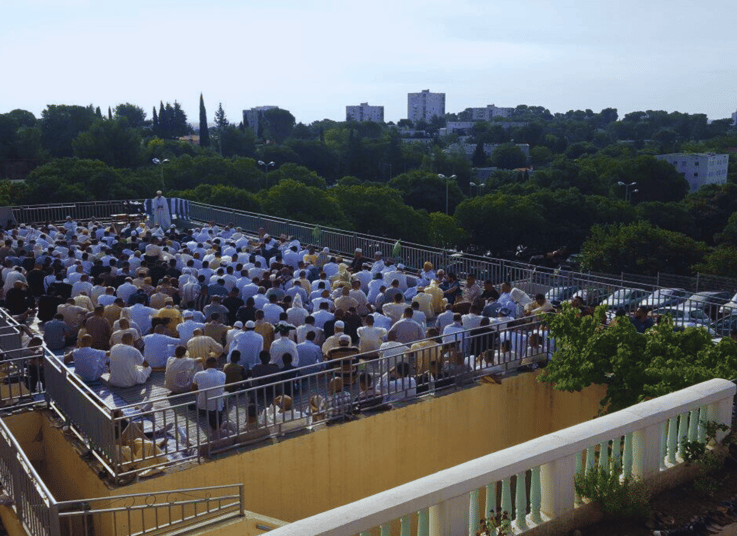Culte musulman en plein air à Nîmes avec nombreux fidèles.
