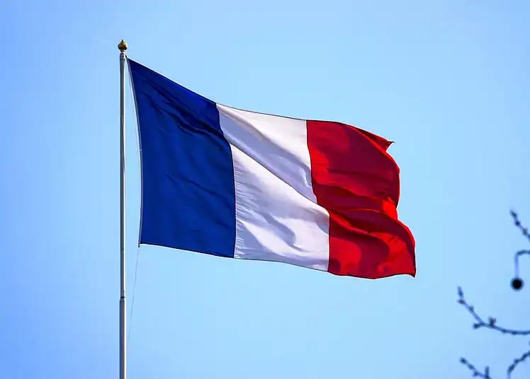 Drapeau français flottant dans le ciel bleu clair.