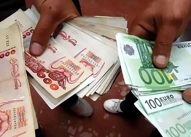 Main tenant des billets de banque en dinar algérien et euro.