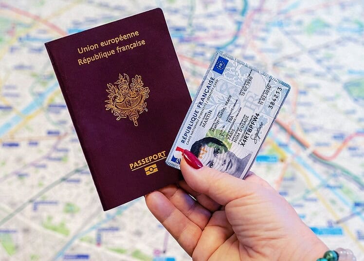 Algériens en France : une permanence consulaire à ne pas manquer Passeport européen et visa dans une main sur une carte de Paris.