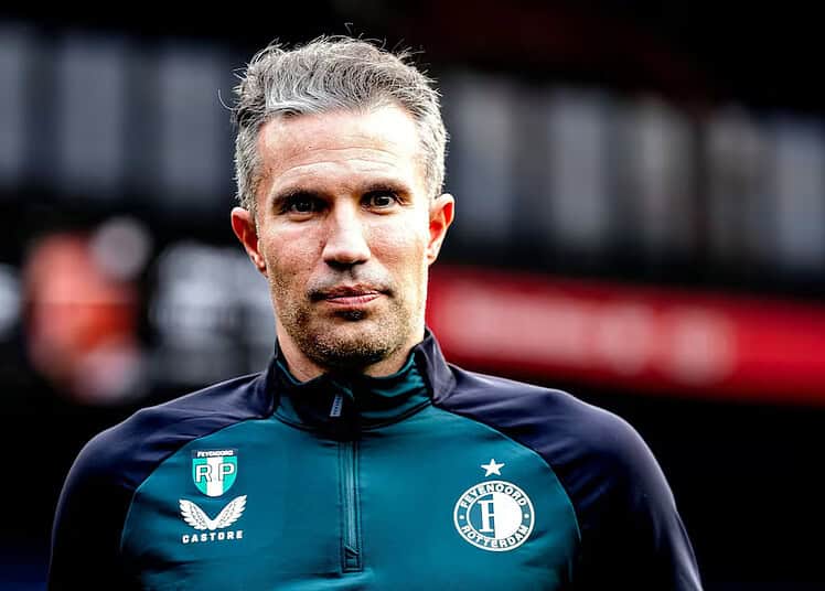 Robin van Persie : Élégance et générosité pendant le Ramadan Robin van Persie lors d'un match de football, concentré et déterminé.