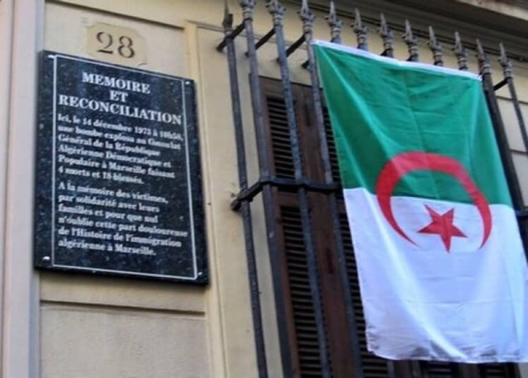 Passeport algérien : ce qui change dans ce consulat en France Drapeau algérien devant une plaque commémorative à Marseille.