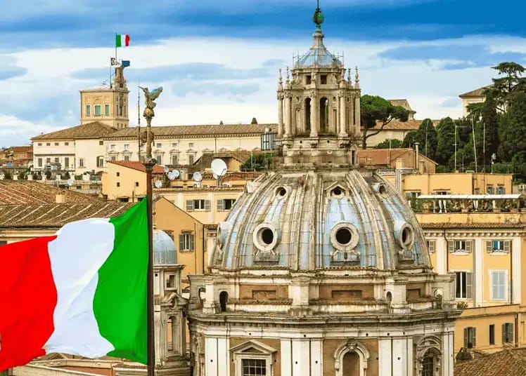 Expulsion des sans-papiers : pourquoi France et Italie s'opposent Drapeau italien flottant avec vue sur Rome historique.