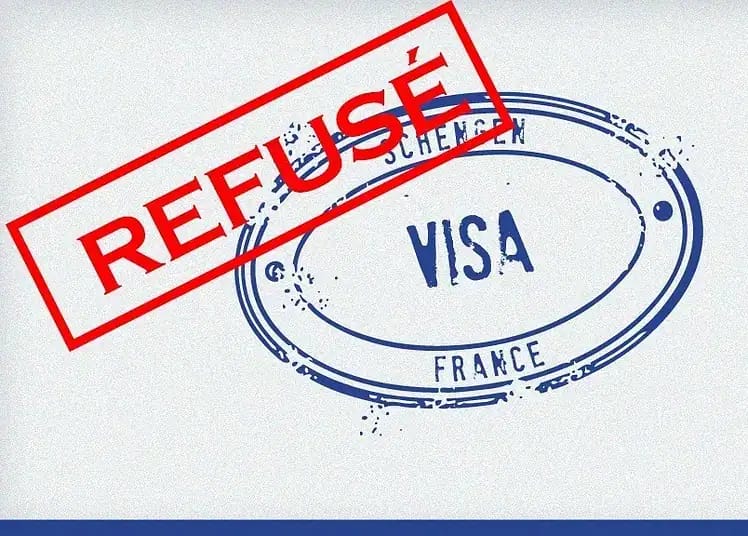 Visa refusé avec stamp rouge 'REFUSÉ' sur document officiel.