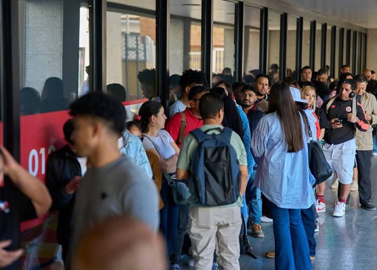 Groupe de migrants faisant la queue dans un centre d'accueil en Espagne.