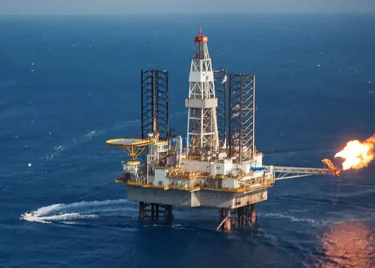Plateforme pétrolière en mer avec flamme de forage en Algérie.