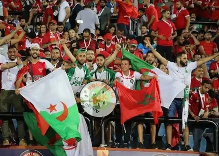 Supporters algériens avec drapeaux lors d'un match de football.