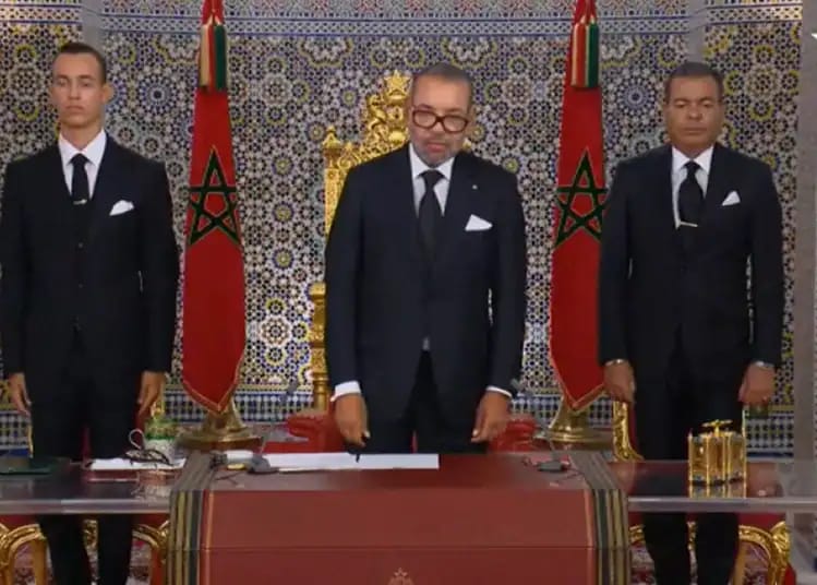 Trois hommes en costume lors d'une cérémonie royale au Maroc.