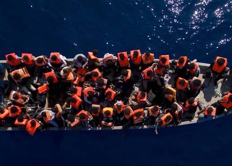 Migrants en mer à bord d'une embarcation sur l'océan.