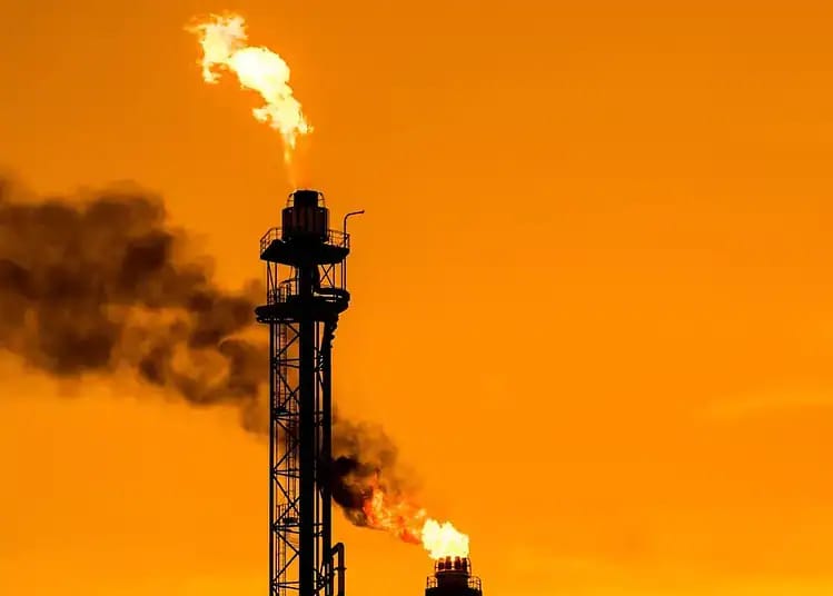Pétrole : Vers un baril à 150$ ? Les indices s'affolent ! Tour de forage pétrolier avec fumée et flamme en Algérie.