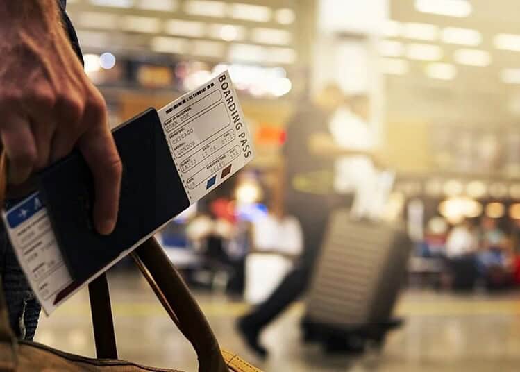 Passager tenant un billet d'embarquement à l'aéroport.