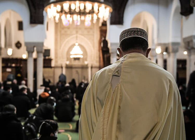 Imam en prière dans une mosquée lors d'une cérémonie religieuse.