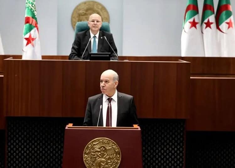 Algérie : Une retraite anticipée à 32 ans ? La réponse du ministre Ministre en séance parlementaire en Algérie avec drapeaux algériens.