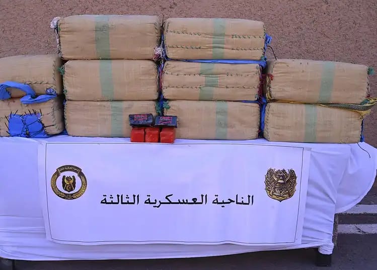 Temmar : 10 ans de prison et saisie totale de ses biens requis Saisie de drogue par l'armée algérienne, sacs de drogue sur une table.