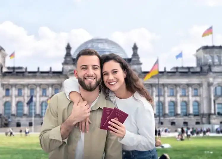 Couple souriant avec passeports devant le Reichstag à Berlin.