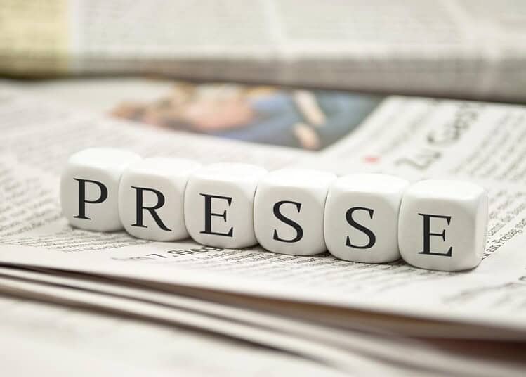 Blocs de lettres formant le mot 'PRESSE' sur un journal.