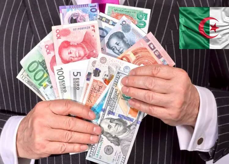 Homme en costume tenant des billets de banque algériens.