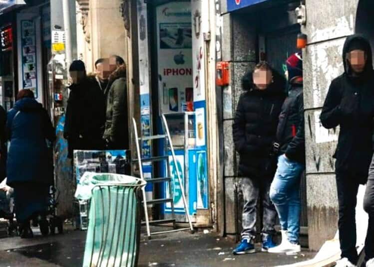 Groupe de personnes devant un magasin à Paris, en attente ou en discussion.