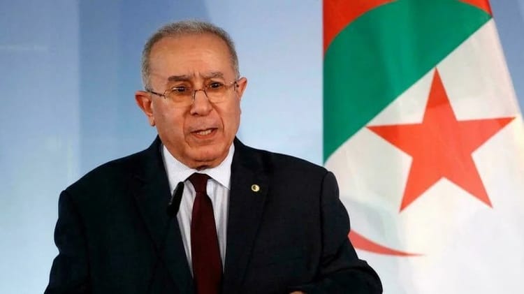 Algérie : Rupture des relations avec le Maroc, Lamamra écarte toute idée de médiation Lamamra s'exprime lors d'une conférence avec drapeau algérien en arrière-plan.