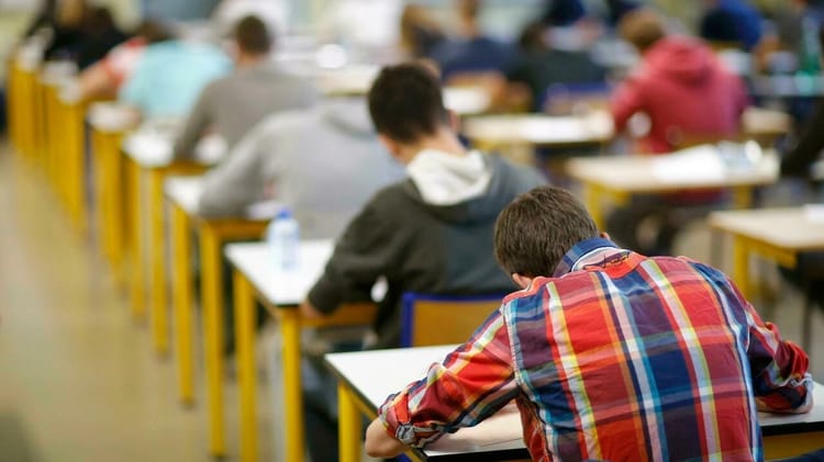 Étudiants passant un examen dans une salle de classe.