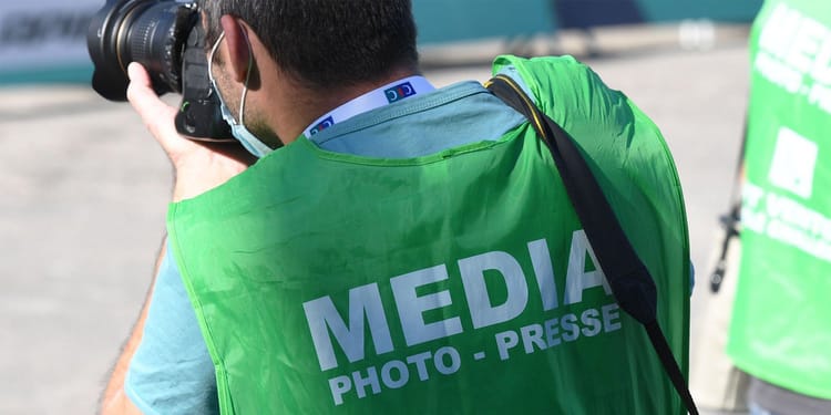 Photographe de presse en train de prendre des photos lors d'un événement public.