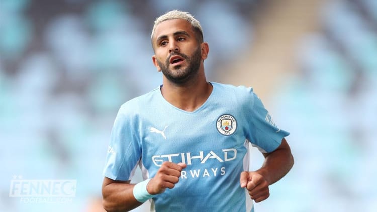 Joueur de football en mouvement portant un maillot Manchester City.