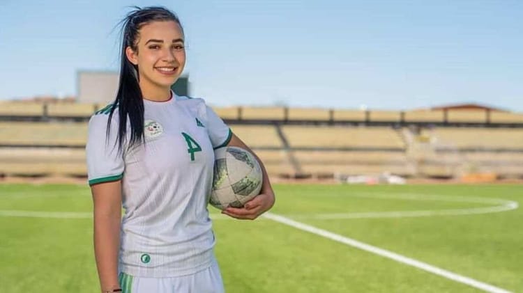 Inégalités salariales dans le foot Dz : Amani pousse un coup de gueule Jeune femme souriante en maillot de football sur le terrain.