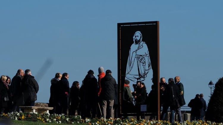 Groupe de personnes devant un portrait de l’émir Abdelkader en Algérie.