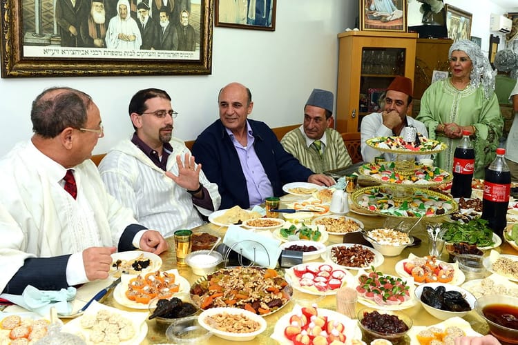 Célébration de la Mimouna avec famille marocaine et plats traditionnels.