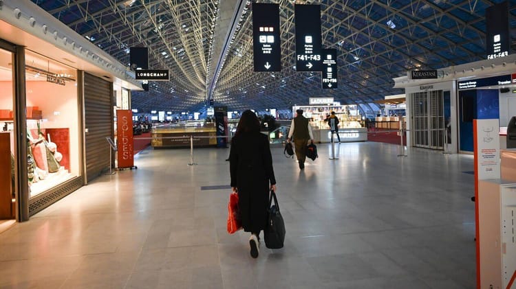 Voyageur dans un aéroport d'Alger avec bagages, intérieur moderne.